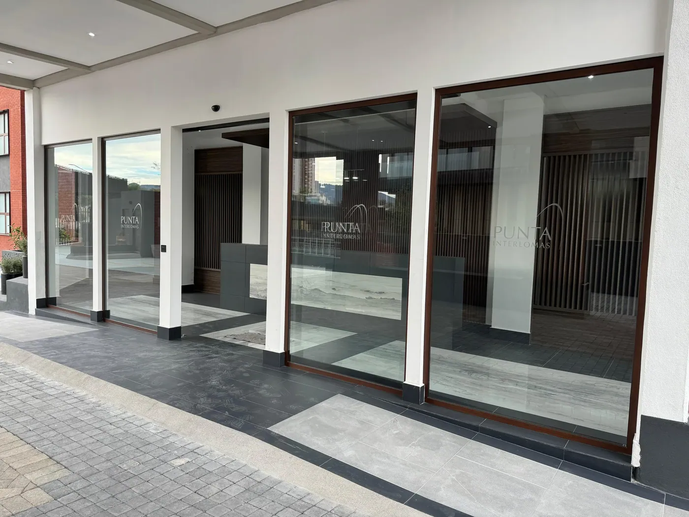 Cancelería de piso a techo en la planta baja comercial de Residencial Punta Interlomas. Suministro e instalación de Luis Llano.